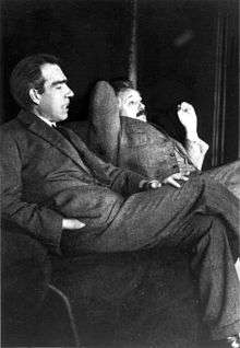 Einstein Bohr konuşurken şüpheci bir şekilde dinliyor.